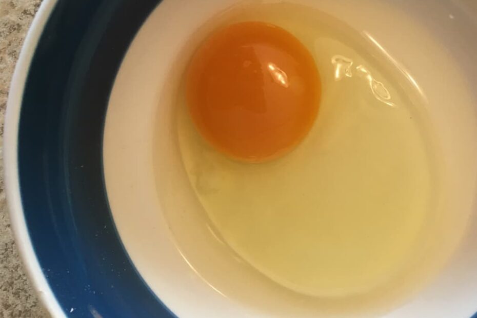 Soy-free pasture-raised egg, cracked into a bowl.
